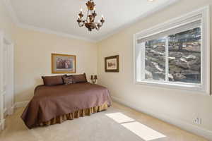 Bedroom featuring carpet floors, crown molding, baseboards, and a notable chandelier