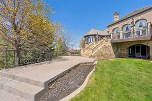 View of yard featuring a patio area, stairway, a balcony, and fence