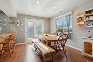 Dining space with wood finished floors, visible vents, recessed lighting, and baseboards