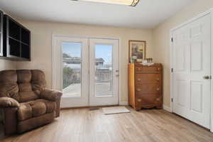 Doorway with visible vents, light wood-style flooring, french doors, and baseboards