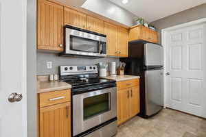 Kitchen featuring stainless steel appliances and light countertops