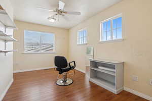 Unfurnished room with ceiling fan, wood finished floors, and baseboards
