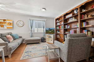 Living area featuring wood finished floors, ceiling fan, and visible vents
