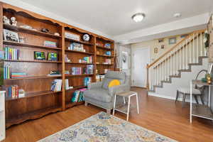 Living area with stairway, wood finished floors, and baseboards