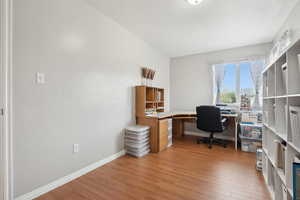 Home office with baseboards and light wood-type flooring