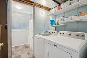 Washroom featuring independent washer and dryer and baseboards