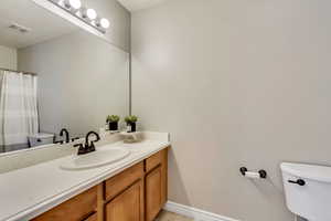 Full bath featuring tile patterned flooring, visible vents, toilet, and vanity