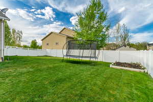 View of yard featuring a fenced backyard and a trampoline