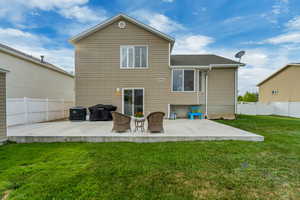 Back of property featuring central AC, a patio area, a fenced backyard, a yard, and roof with shingles