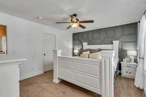 Bedroom with a ceiling fan, baseboards, and light colored carpet