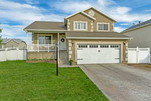 Tri-level home with a front lawn, fence, a garage, and covered porch
