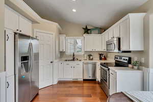 Kitchen with white cabinets, stainless steel appliances, a sink, recessed lighting, and light countertops