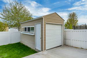 Detached garage featuring a trampoline and fence