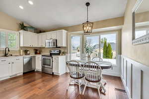 Kitchen with a sink, visible vents, an inviting chandelier, light countertops, and appliances with stainless steel finishes