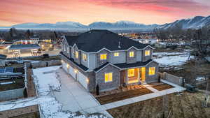 View of front of property featuring a garage, a mountain view, fence, and stone siding