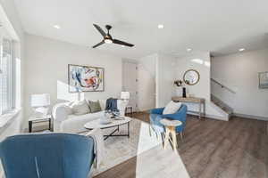 Living area with stairway, wood finished floors, ceiling fan, and recessed lighting
