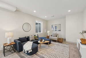 Carpeted living room featuring recessed lighting, visible vents, and baseboards