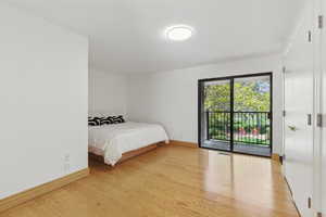 Bedroom featuring visible vents, light wood-type flooring, access to exterior, and baseboards
