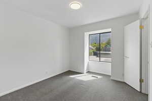 Carpeted spare room featuring baseboards and visible vents