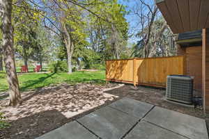 View of patio with fence and central AC unit