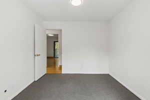 Carpeted empty room with baseboards