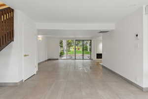 Unfurnished living room with visible vents, a fireplace with raised hearth, and baseboards