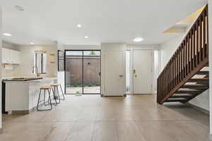 Foyer featuring stairway, light tile patterned floors, and recessed lighting