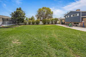 View of yard with a trampoline, a fenced backyard, and a patio area