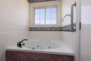 Full bathroom with a whirlpool tub