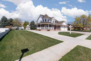 Victorian-style house featuring driveway, a gazebo, a porch, brick siding, and a front yard