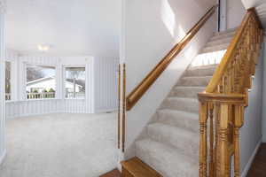 Staircase with carpet floors and baseboards