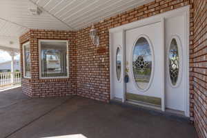Doorway to property featuring brick siding