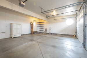 Garage featuring a garage door opener and baseboards