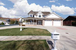 View of front of home featuring a front lawn, covered porch, brick siding, and concrete driveway