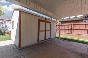 View of shed featuring fence