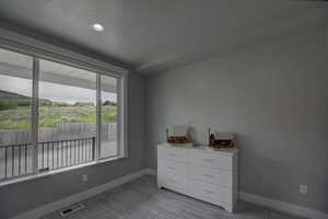 Bedroom with wood finish floors, a textured ceiling, visible vents, and baseboards
