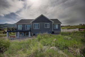 Back of house featuring central air condition unit and a wooden deck