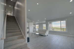 Stairs with recessed lighting, wood finished floors, and baseboards