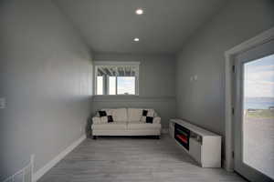 Sitting room with visible vents, recessed lighting, light wood-style floors, and baseboards