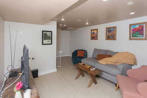 Living room with light wood finished floors, recessed lighting, and baseboards