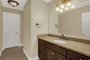 South Bedroom Bathroom featuring tile patterned floors, a notable chandelier, vanity, and baseboards