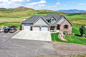 Craftsman house featuring a front yard, a garage, driveway, board and batten siding, and fence