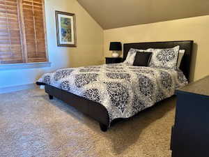Carpeted bedroom with vaulted ceiling