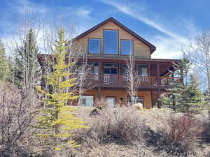 Front view of home with 3 sided covered deck