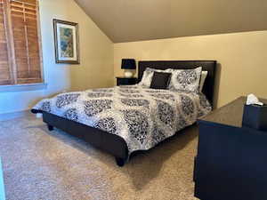 Carpeted bedroom featuring lofted ceiling