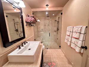 3/4 bath with baseboards, a steam shower stall, toilet, and vanity