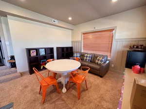 daylight basement family room with recessed lighting, carpet floors, and a wainscoted wall
