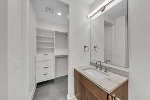 Bathroom with vanity, light tile patterned floors, and recessed lighting