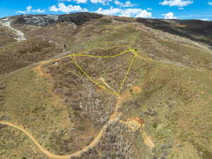 Aerial view of property and surrounding area featuring a mountain backdrop and approximate property parcel outline