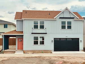 Modern farmhouse featuring driveway, an attached garage, board and batten siding, and roof with shingles